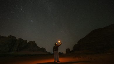 a person standing in the desert holding a lantern
